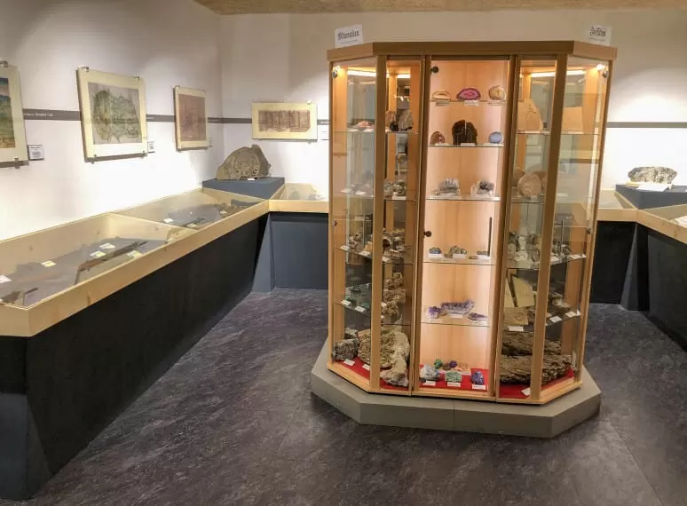 Ausstellungsvitrine mit verschiedenen Mineralien und dazugehörigen Beschreibungen auf Kärtchen. 