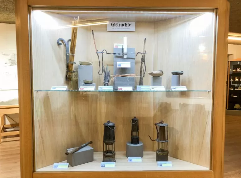 Ausstellungsvitrine mit historischen Grubenlampen und Werkzeugen. 